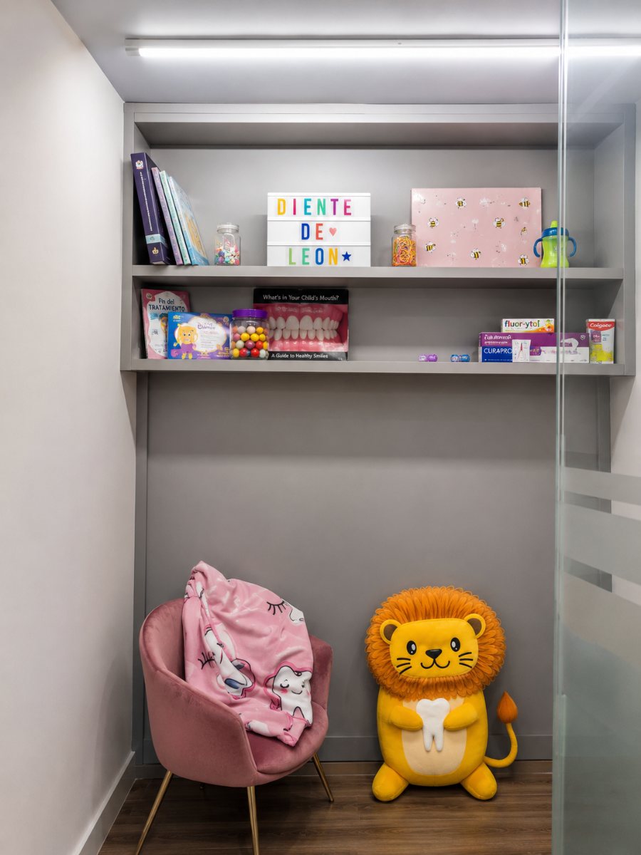 Rincón de espera con el peluche de Chuletón, sillón rosa y el letrero de Diente de León